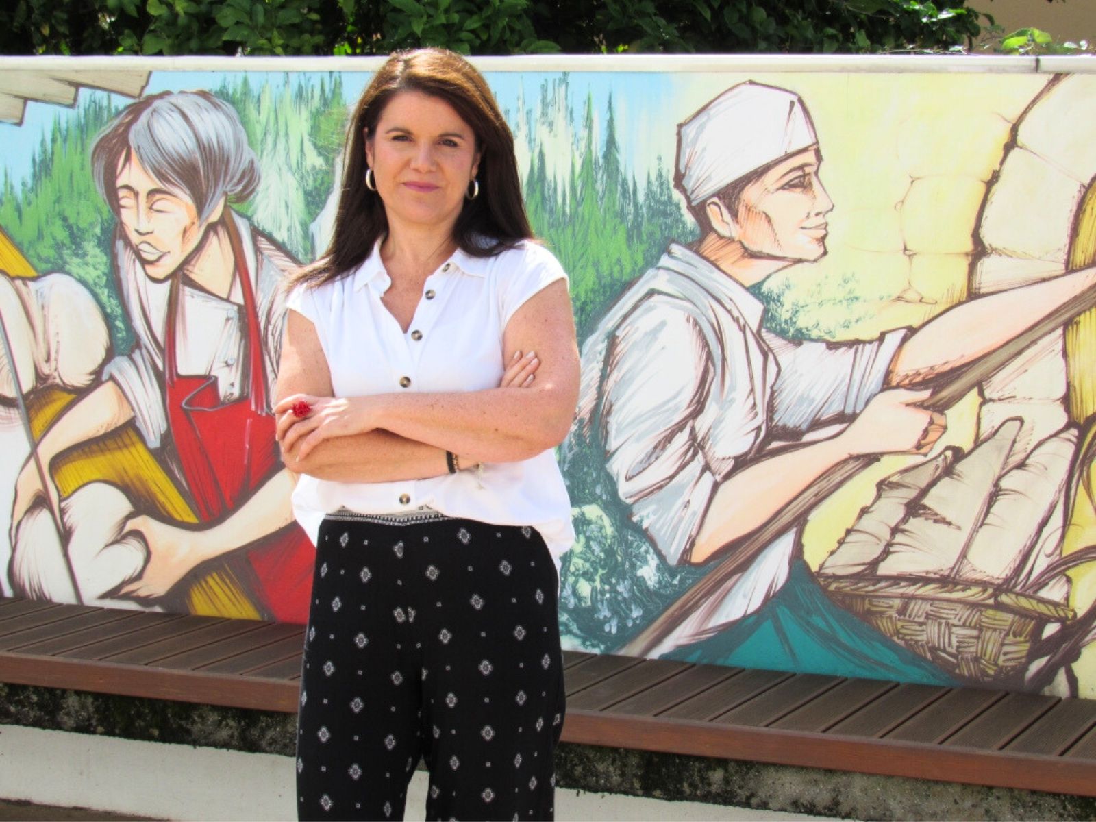 A xornalista Ada Romero xunto ao mural da Praza do Concello de Neda