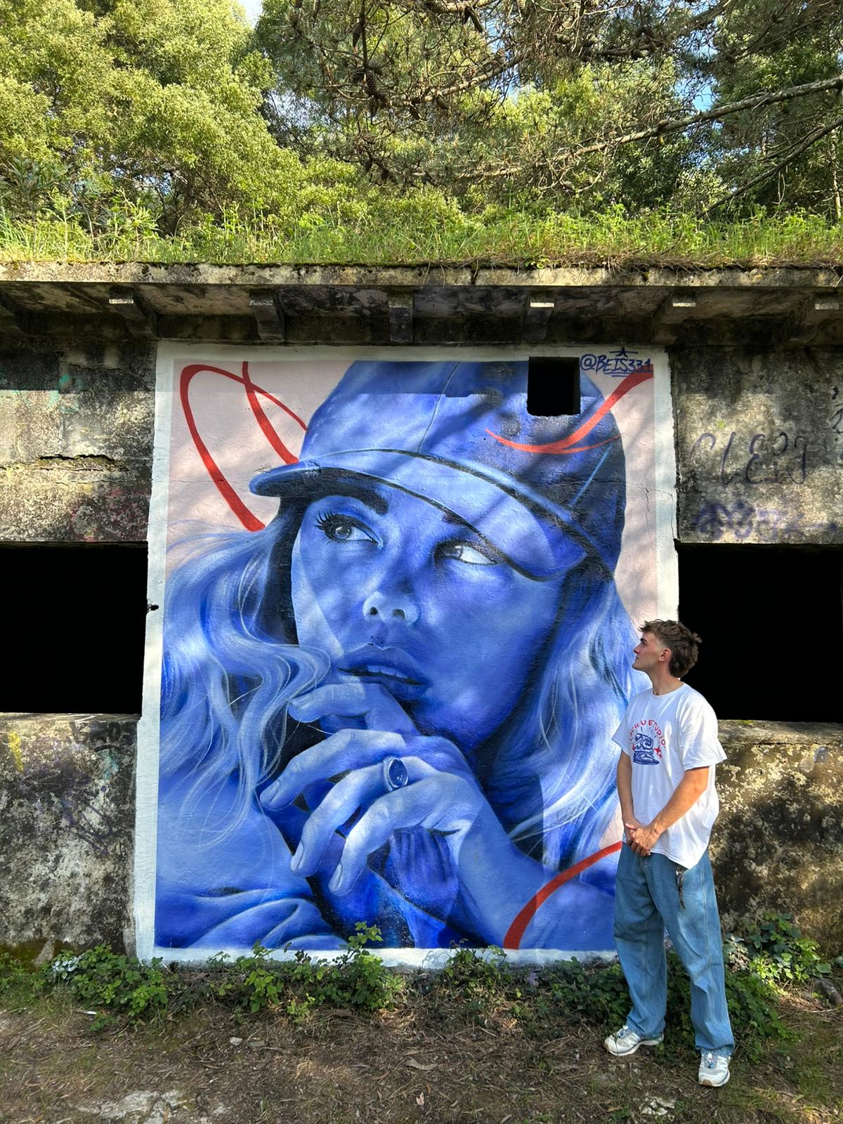 O artista vigués Pedro Gonzalo, Beiss, xunto a un dos seus murais